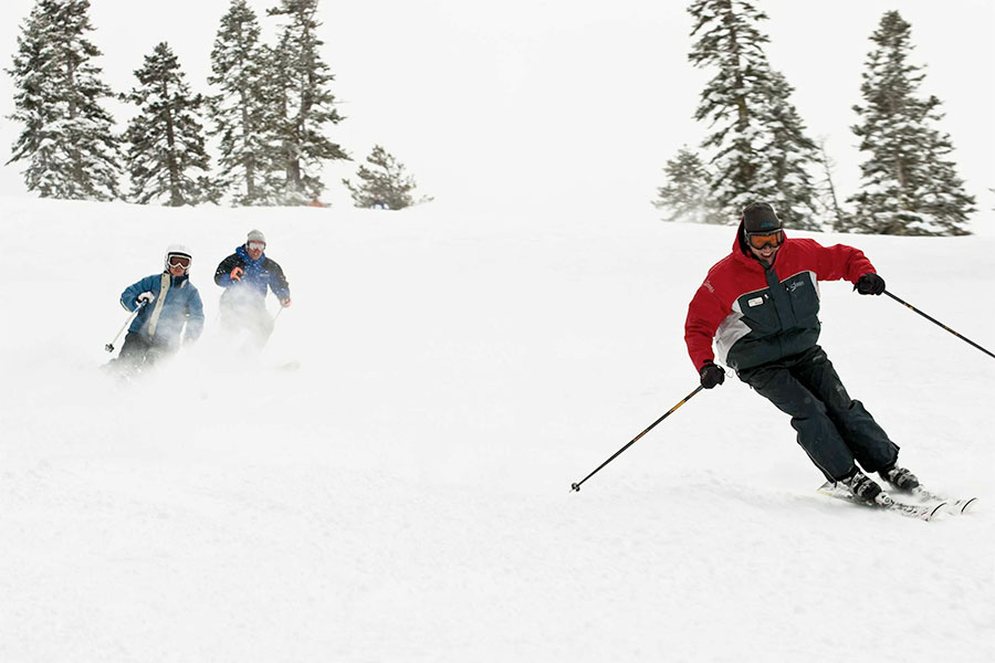 Lessons at Sierra - Skiers Carving Down Mountain